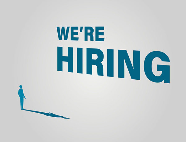 a man standing in front of a sign that says we're hiring.