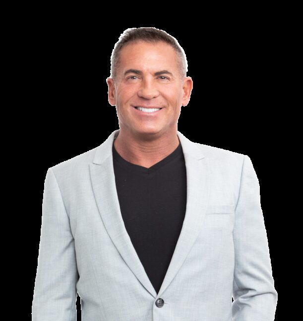 a man in a blue shirt smiles at the camera.