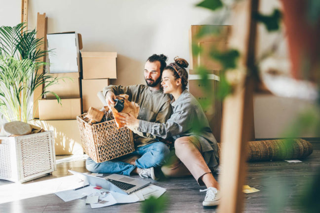a man and woman sitting on the floor with a dog