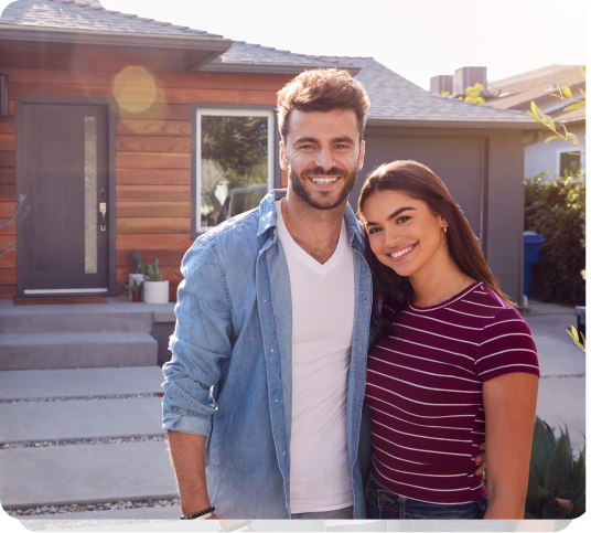 a man and a woman standing in front of a house