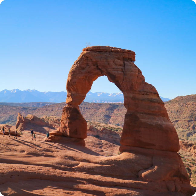 delicate arch with tourists in the background in moab utah